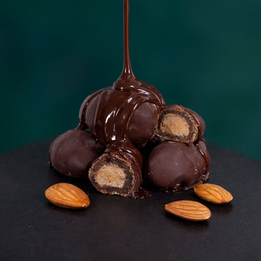 Datteln umhüllt von dunkler Schokolade, dekorativ serviert