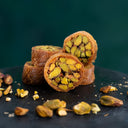 Mabroumeh Gebäck mit Pistazienfüllung, angerichtet auf dunklem Untergrund